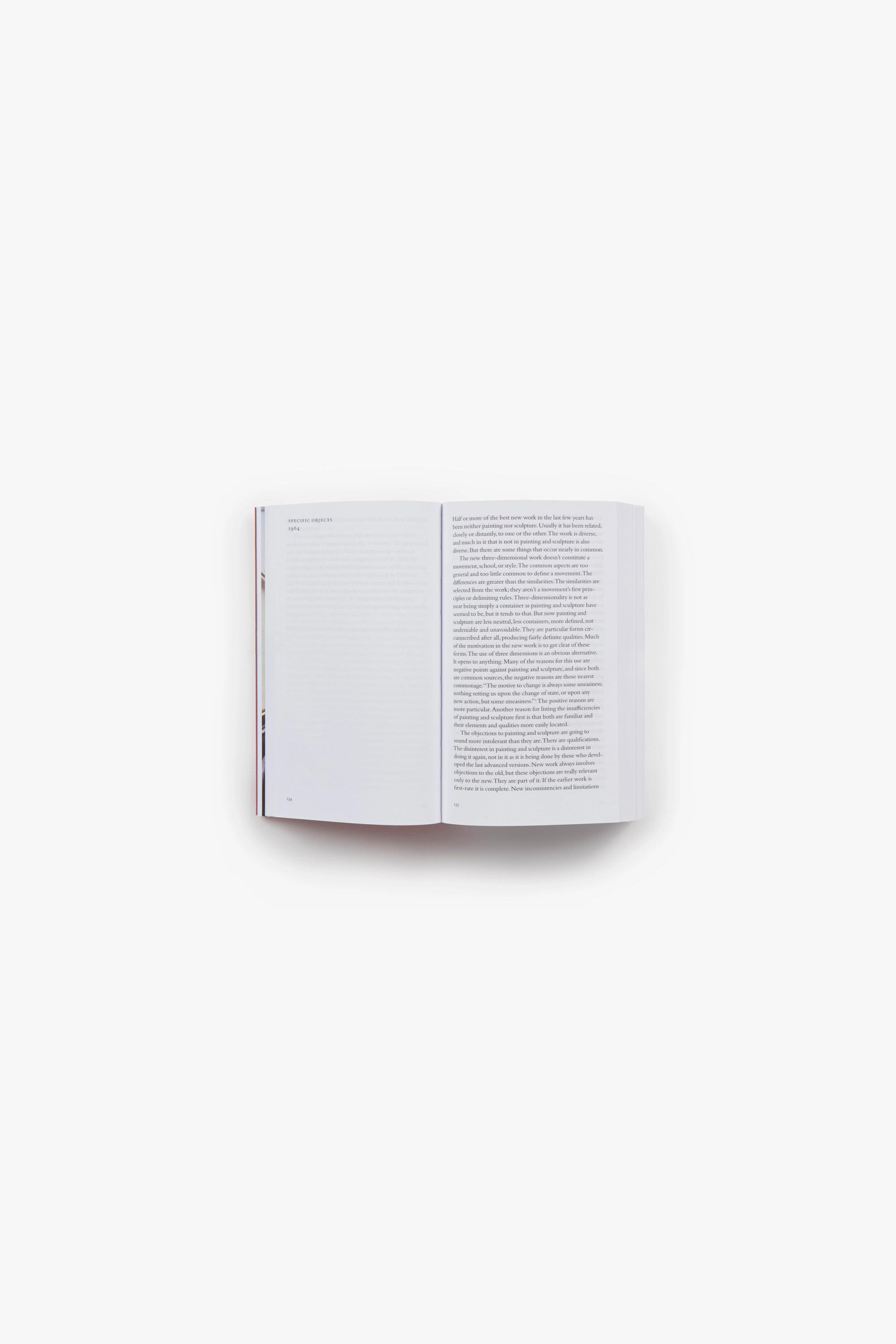 Full spread of “Donald Judd Writings.” Verso is a title page, with the text set in small caps: “Specific Objects. 1964.” Recto is page of text.