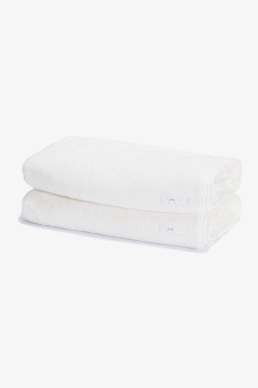Two white folded towels, stacked on top of each other
